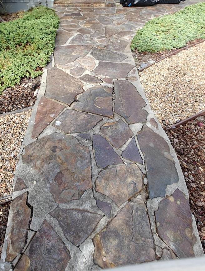 Worn and uneven flagstone walkway before reconstruction in Monterey County residential yard